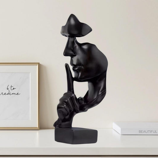Scultura decorativa volto astratto nero con gesto di silenzio su mensola